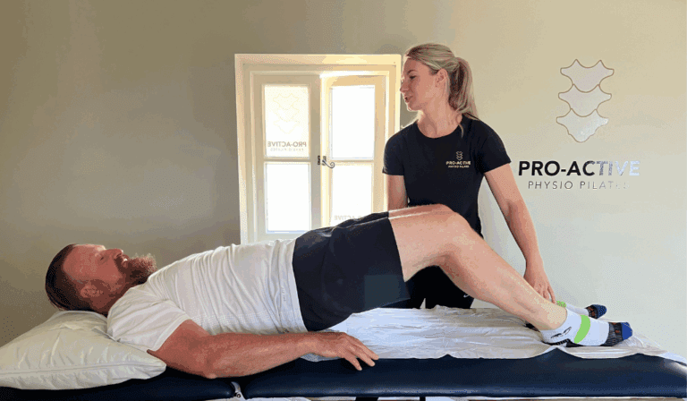 Pro-active Physio assisting glut bridges with a patient.