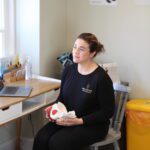Pelvic health physio holding a model pelvis talking to a patient at pro-active physio pilates