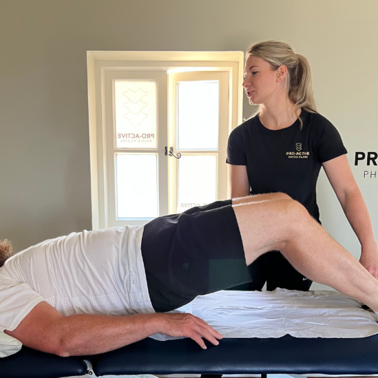 Pro-active Physio assisting glut bridges with a patient.